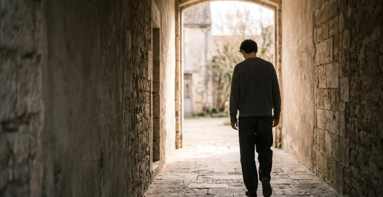 Silhouette d'une personne avançant depuis un couloir sombre vers une lumière douce et naturelle, symbolisant le chemin de la guérison face à la dépression